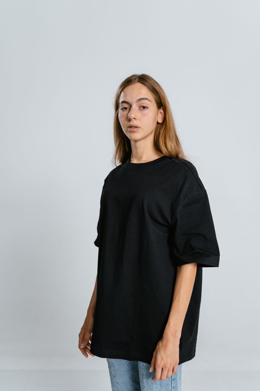 Portrait of a woman wearing a plain black oversized t-shirt — restrained, considered